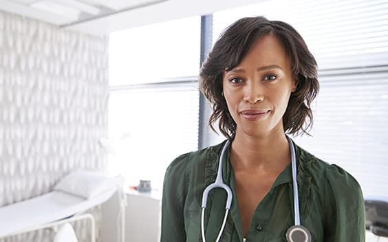 Middle-aged Black woman doctor in an exam room.